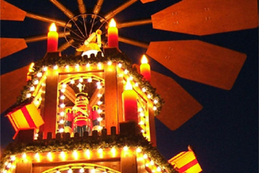 Ein Windrad mit Lichtern und Kerzen auf der Spitze, das eine festliche Atmosphäre ausstrahlt.